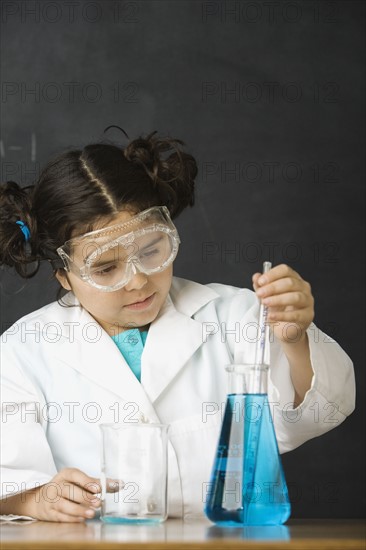 Girl measuring liquid in science class. Date : 2008