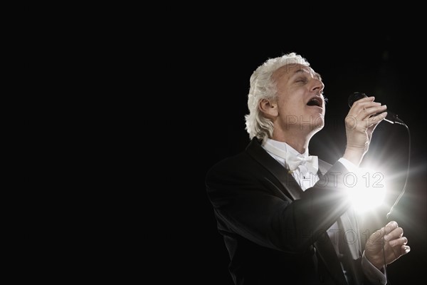 Man in tuxedo singing into microphone. Date : 2008