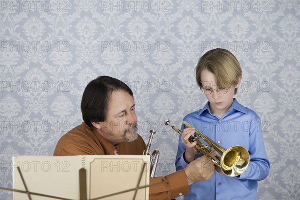 Music teacher teaching boy to play trumpet. Date : 2008