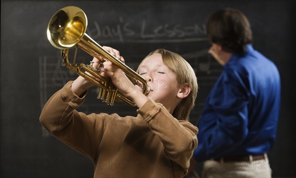 Boy playing trumpet in classroom. Date : 2008