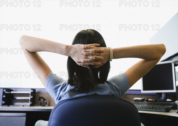 Businesswoman with hands behind head. Date : 2008