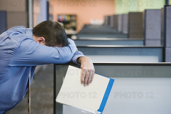 Businessman leaning head on cubicle wall. Date : 2008