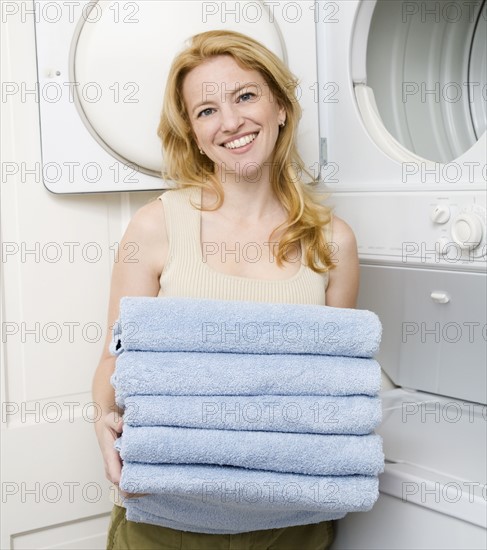 Woman holding folded towels. Date : 2008