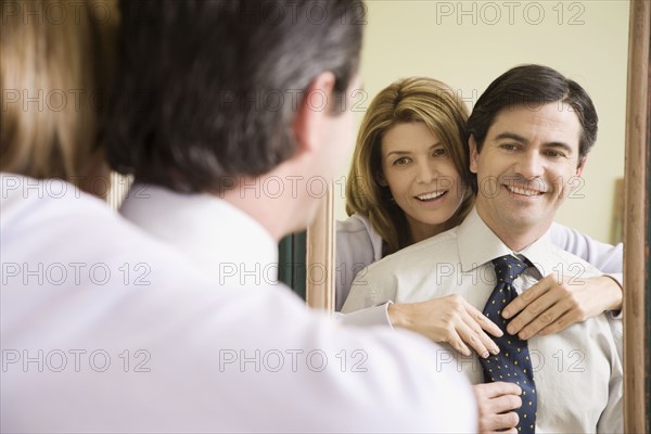 Woman adjusting husband’s necktie. Date : 2008