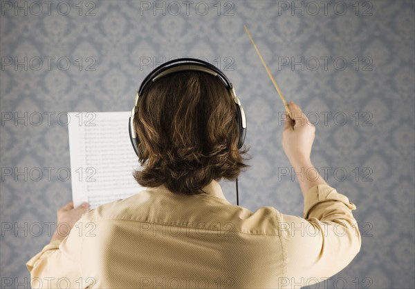 Man listening to headphones and conducting. Date : 2008