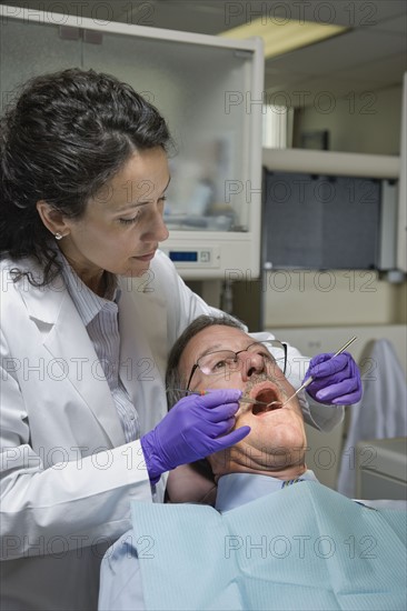 Female dentist examining patient. Date : 2008