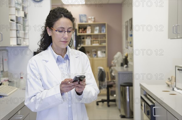 Female doctor dialing cell phone. Date : 2008