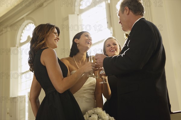 Wedding party toasting in church. Date : 2008