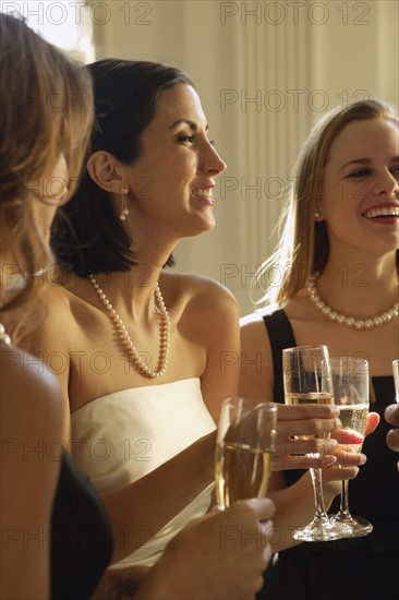 Bride drinking champagne with friends. Date : 2008