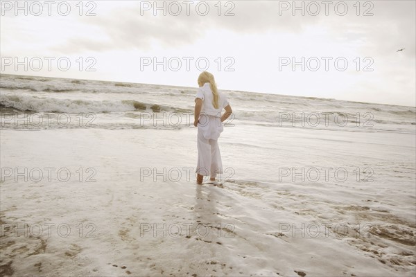 Girl standing in ocean surf. Date : 2008