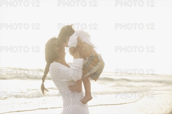 Mother holding son at beach. Date : 2008