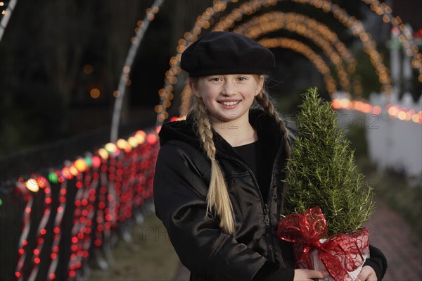 Girl holding potted plant. Date : 2008