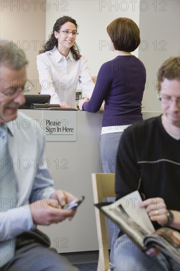 Receptionist talking to woman at counter. Date : 2008