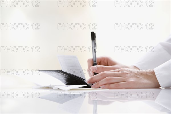 Woman writing check. Date : 2008