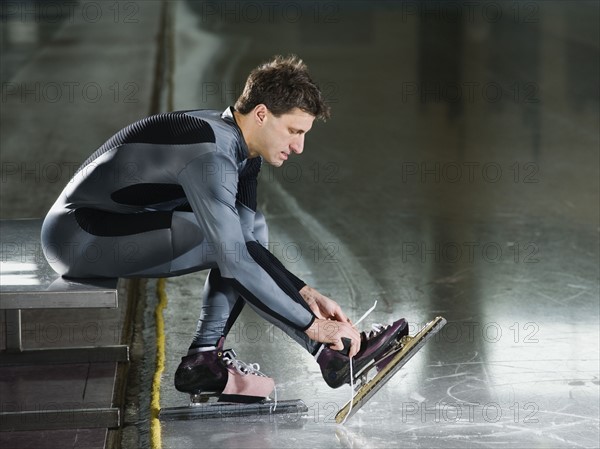 Male speed skater ties skate lace. Date : 2008