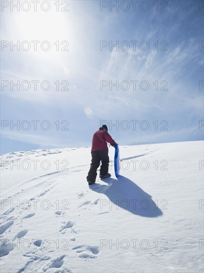 Boy carrying sled in snow. Date : 2008