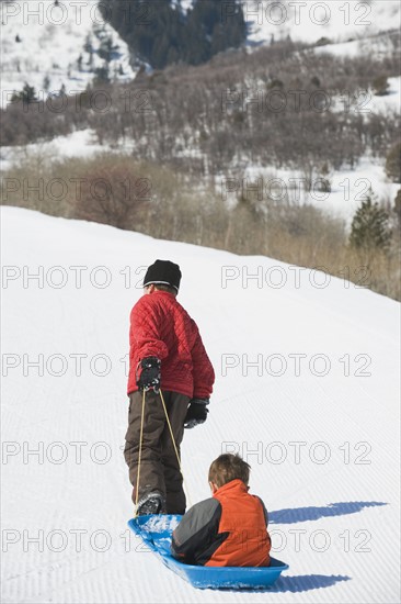 Boy pulling brother in sled. Date : 2008