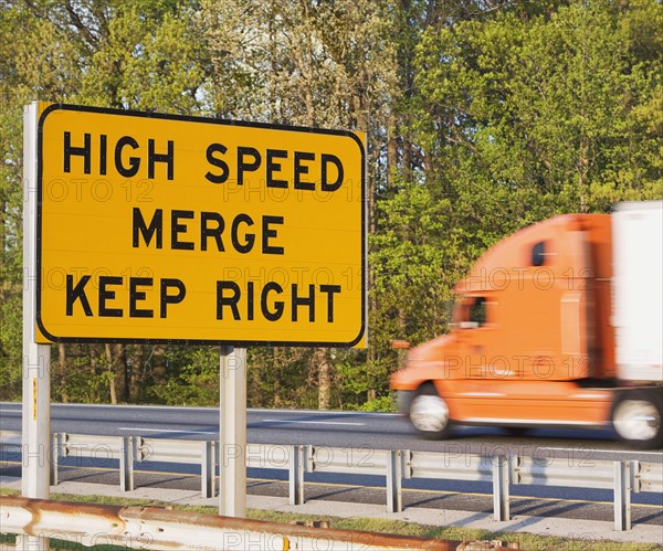 Blurred motion shot of truck driving past street sign. Date : 2008