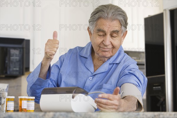 Senior man taking own blood pressure. Date : 2008