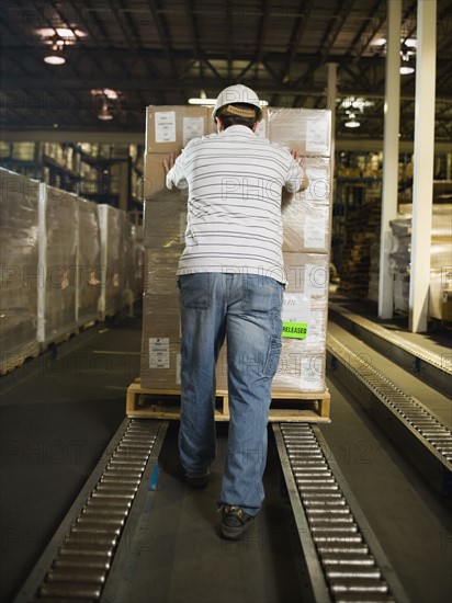 Warehouse worker pushing palette. Date : 2008