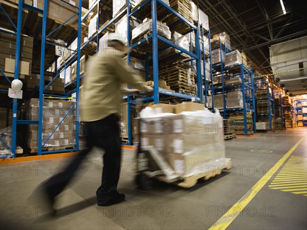 Warehouse worker pushing palette. Date : 2008