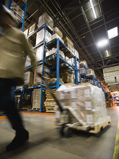 Warehouse worker pulling palette. Date : 2008