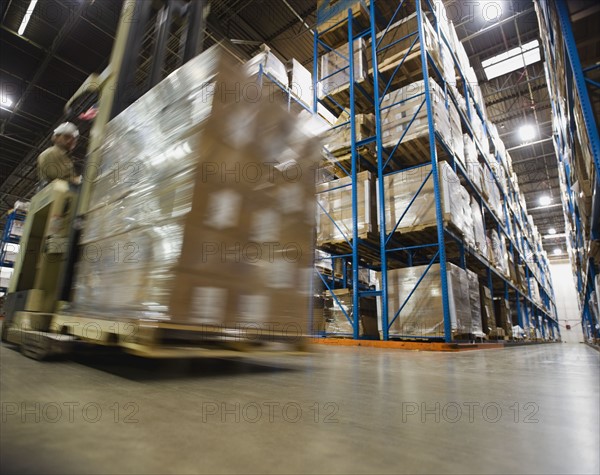 Warehouse worker driving forklift with palette. Date : 2008