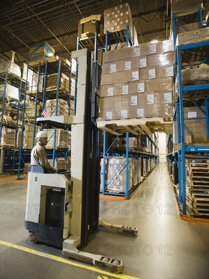 Warehouse worker driving forklift. Date : 2008