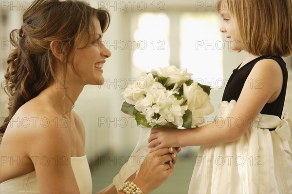 Bride handing bouquet to flower girl. Date : 2008