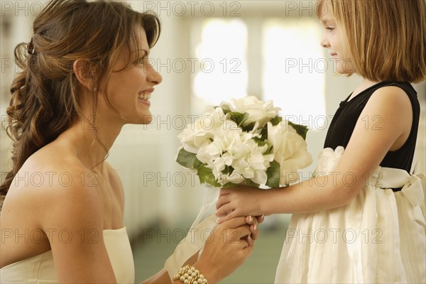 Bride handing bouquet to flower girl. Date : 2008