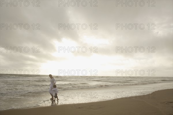 Mother and child walking on beach. Date : 2008