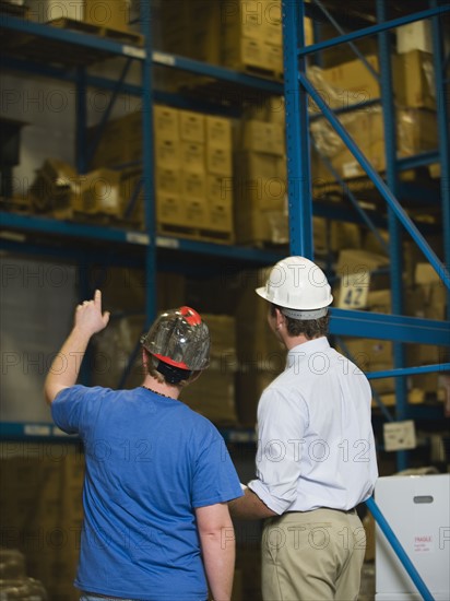 Warehouse workers looking at inventory. Date : 2008