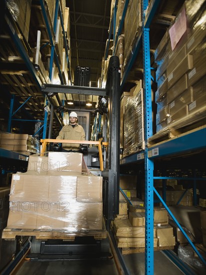 Warehouse worker driving forklift with palette. Date : 2008