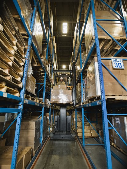 Warehouse worker driving forklift with palette. Date : 2008