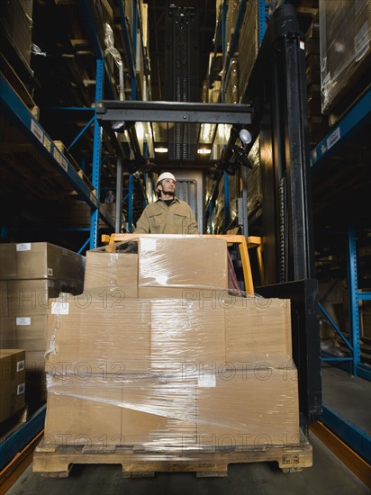 Warehouse worker driving forklift with palette. Date : 2008