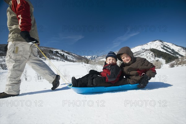 Father pulling children on sled. Date : 2008