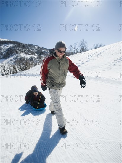 Father pulling children on sled. Date : 2008