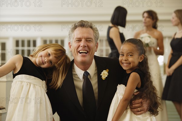 Father of bride hugging flower girls. Date : 2008