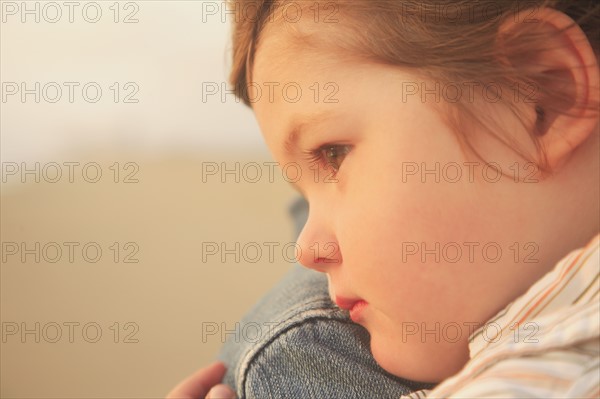 Close up of child resting on parent’s shoulder. Date : 2008