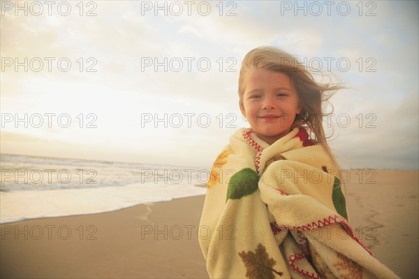Girl wrapped in blanket at beach. Date : 2008