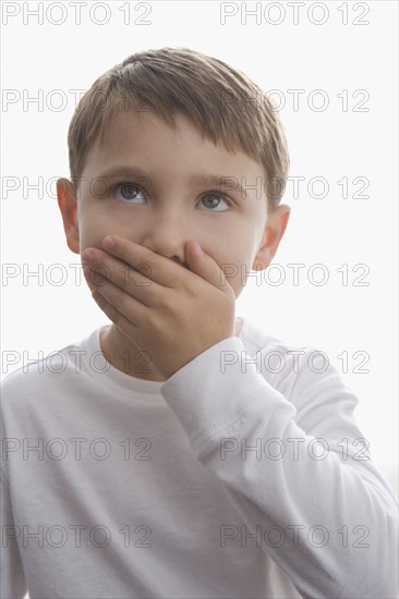 Boy covering mouth with hand. Date : 2008