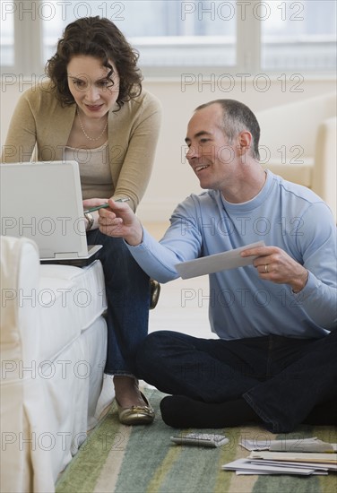 Couple paying bills online at home.