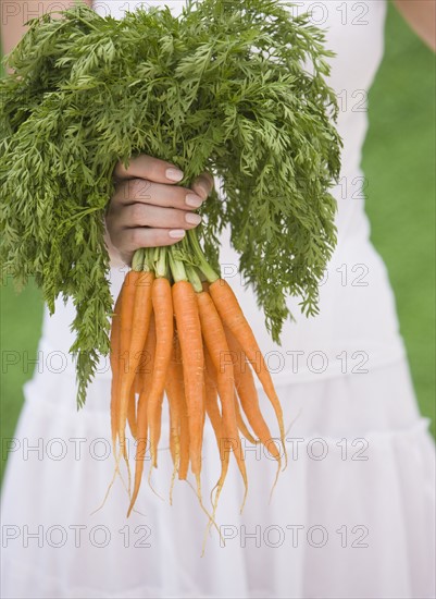 Woman holding fresh carrots.