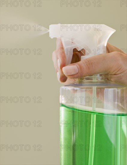 Close up of hand and spray bottle.