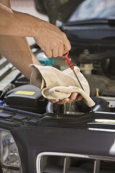 Mechanic checking oil.