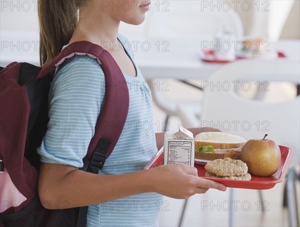 Girl carrying lunch tray at school.