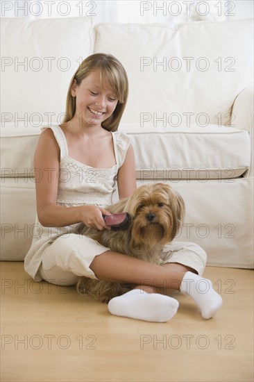 Girl grooming dog.