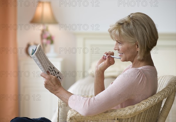 Woman doing crossword puzzle.