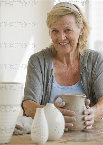 Senior woman making ceramic pots.