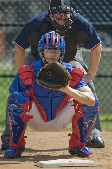 Baseball pitcher and umpire in ready position.
